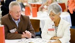 Photos of a pair of alums from the Class of 1967 at their 50th reunion reviewing yearbook.